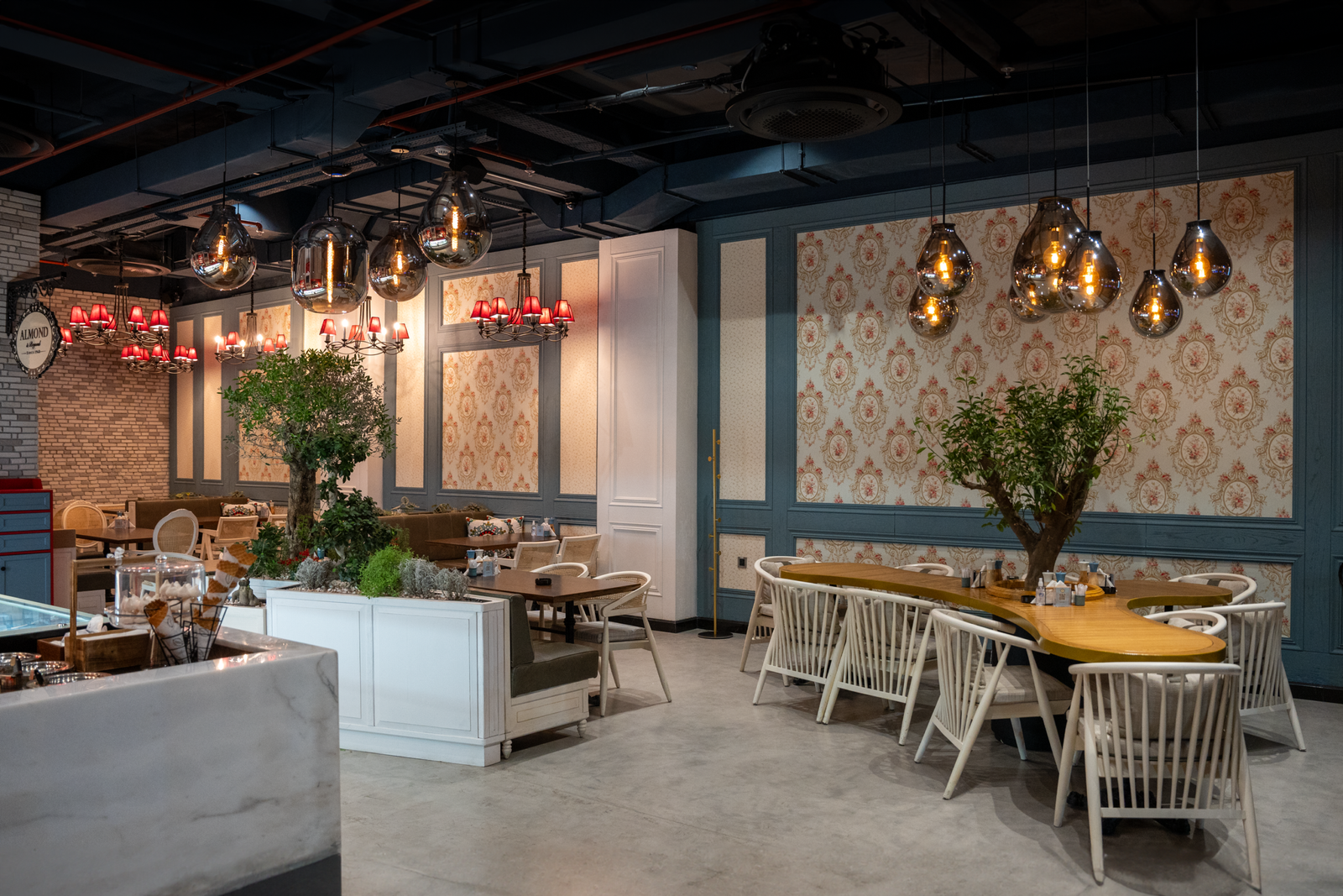 Stylish cafe interior in Erbil with modern chandeliers and elegant seating arrangement.