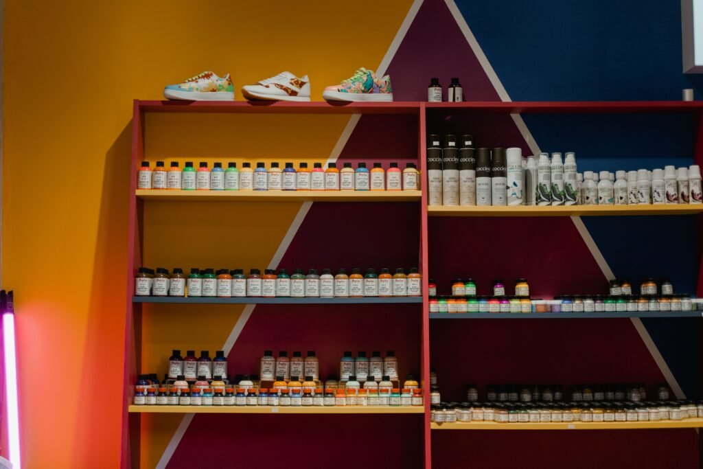 Colorful bottles and shoes arranged neatly on a vibrant geometric shelf display.